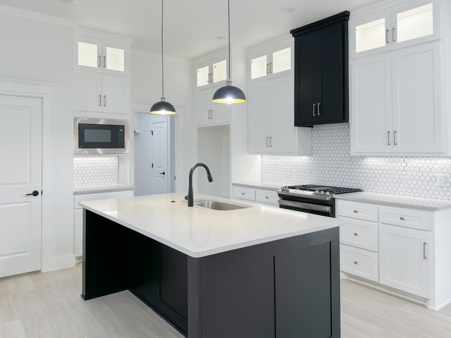 1301 Abbey Road Wolfforth, TX 79382 - Photo 10 of 24 a kitchen with a sink dishwasher and a stove with wooden floor