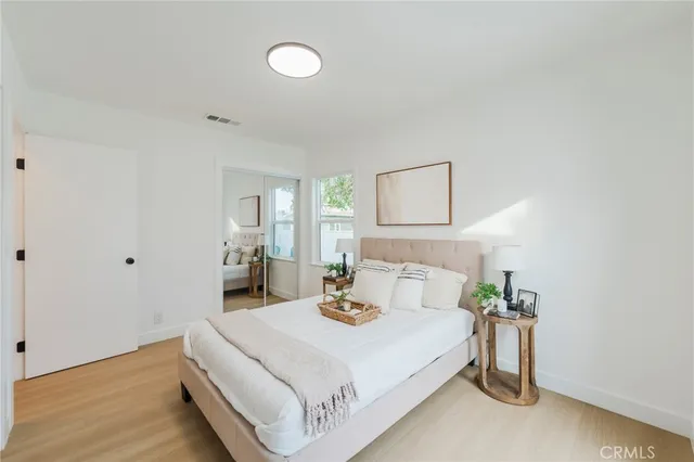 a bedroom with a bed and wooden floor