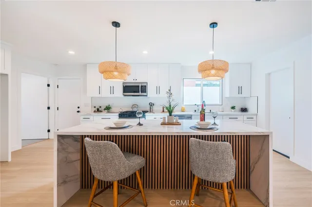 a kitchen with kitchen island granite countertop a sink a center island a table and chairs