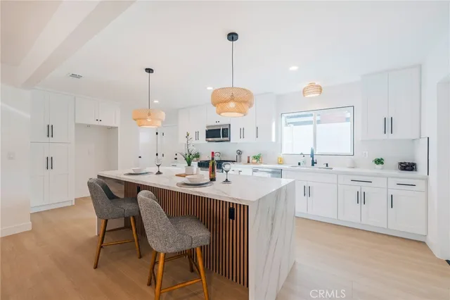 a kitchen with center island table and chairs