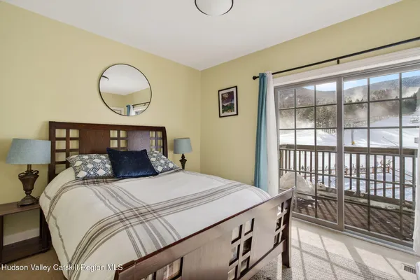 a bedroom with a large bed and wooden floor