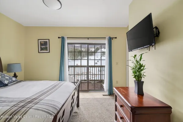 a bedroom with a bed table and flat screen tv
