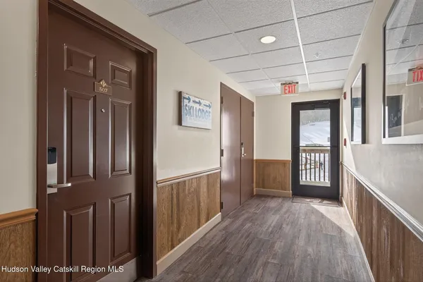 a view of a hallway with wooden floor and staircase