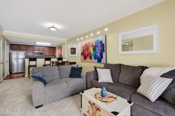 a living room with furniture and kitchen view