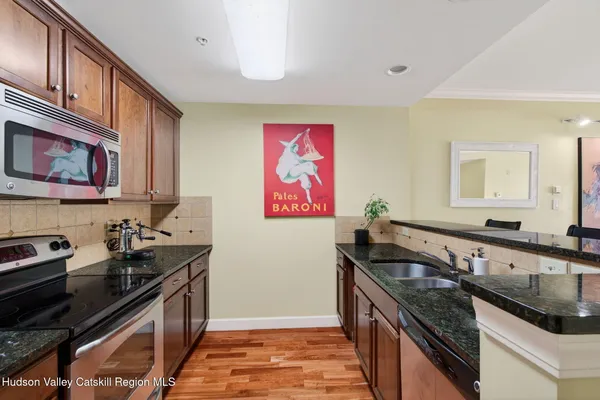 a kitchen with granite countertop a sink stove and cabinets