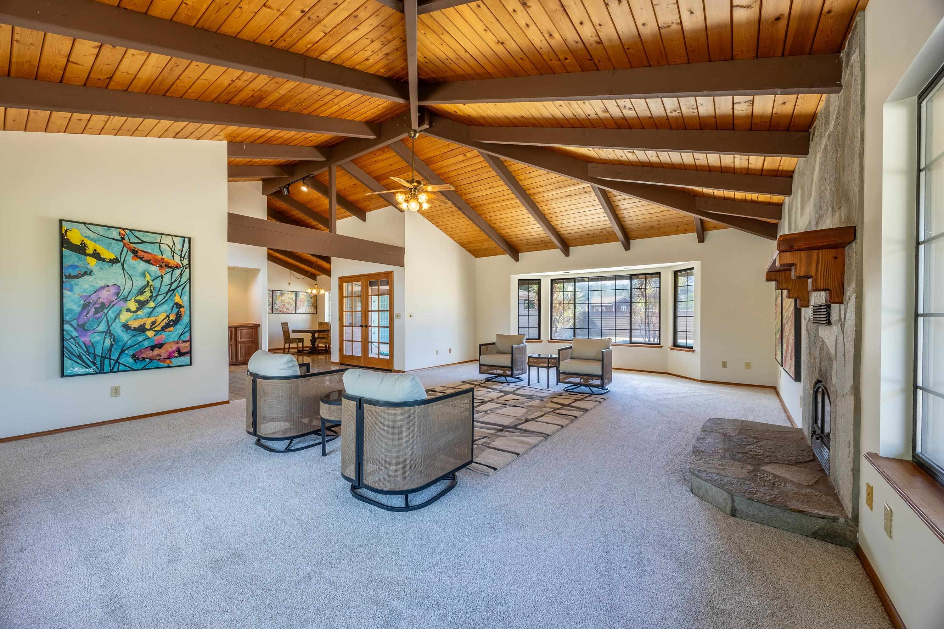 128 Hoopalua Drive Makawao, HI 96768 - Photo 11 of 50 a living room with furniture a flat screen tv and a large window