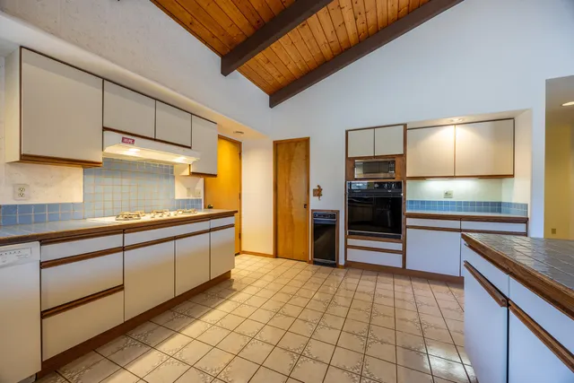 a large kitchen with a large counter top and stainless steel appliances