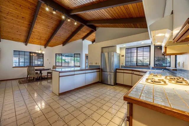 a kitchen with stainless steel appliances granite countertop a sink a stove and a refrigerator