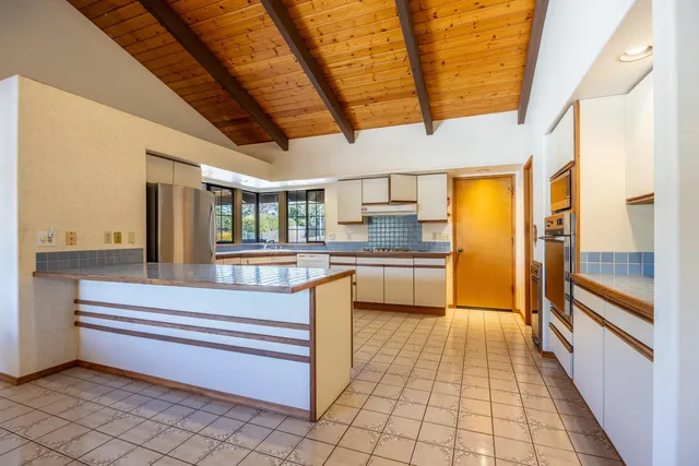 a open kitchen with a sink and refrigerator