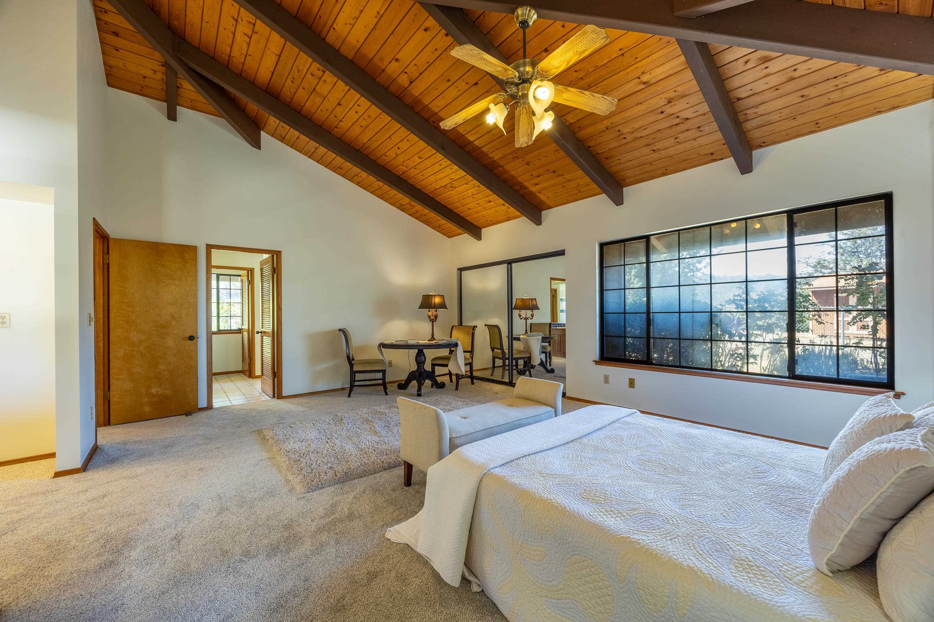 128 Hoopalua Drive Makawao, HI 96768 - Photo 28 of 50 a spacious bedroom with a bed and a large window