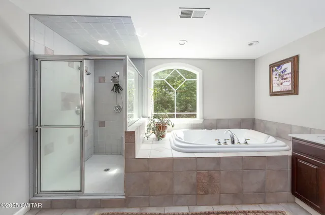 a bathroom with a tub a sink and a large mirror