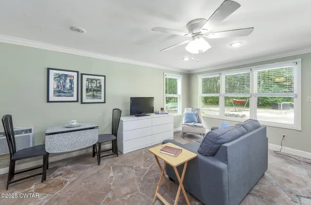 a living room with furniture a large window and a flat screen tv