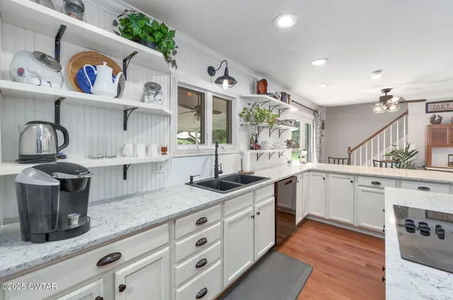 a kitchen with stainless steel appliances granite countertop a sink and cabinets