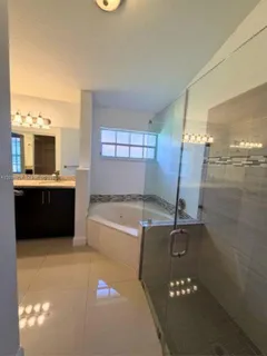 a bathroom with a tub sink and mirror