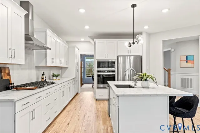 a kitchen with stainless steel appliances kitchen island granite countertop a sink and cabinets