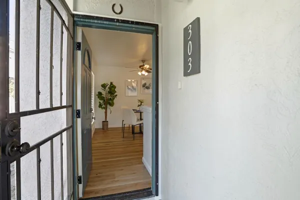 a view of a hallway with wooden floor and a livingroom