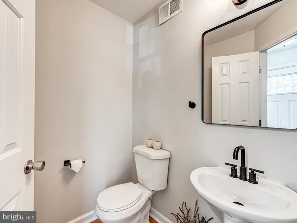 a bathroom with a sink a toilet and mirror
