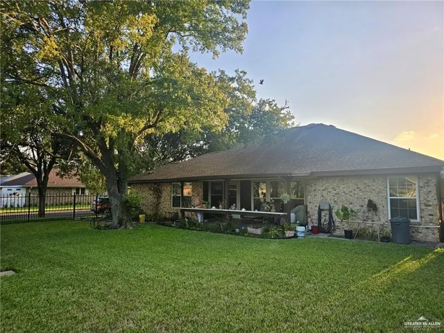 a view of a house with a backyard and a tree