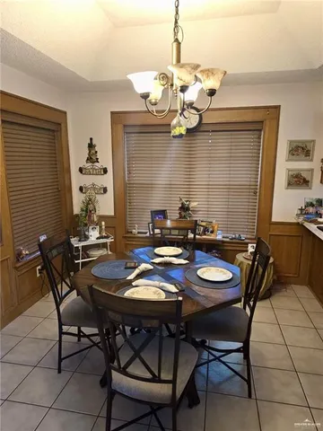 a view of a dining room and livingroom with furniture wooden floor a chandelier