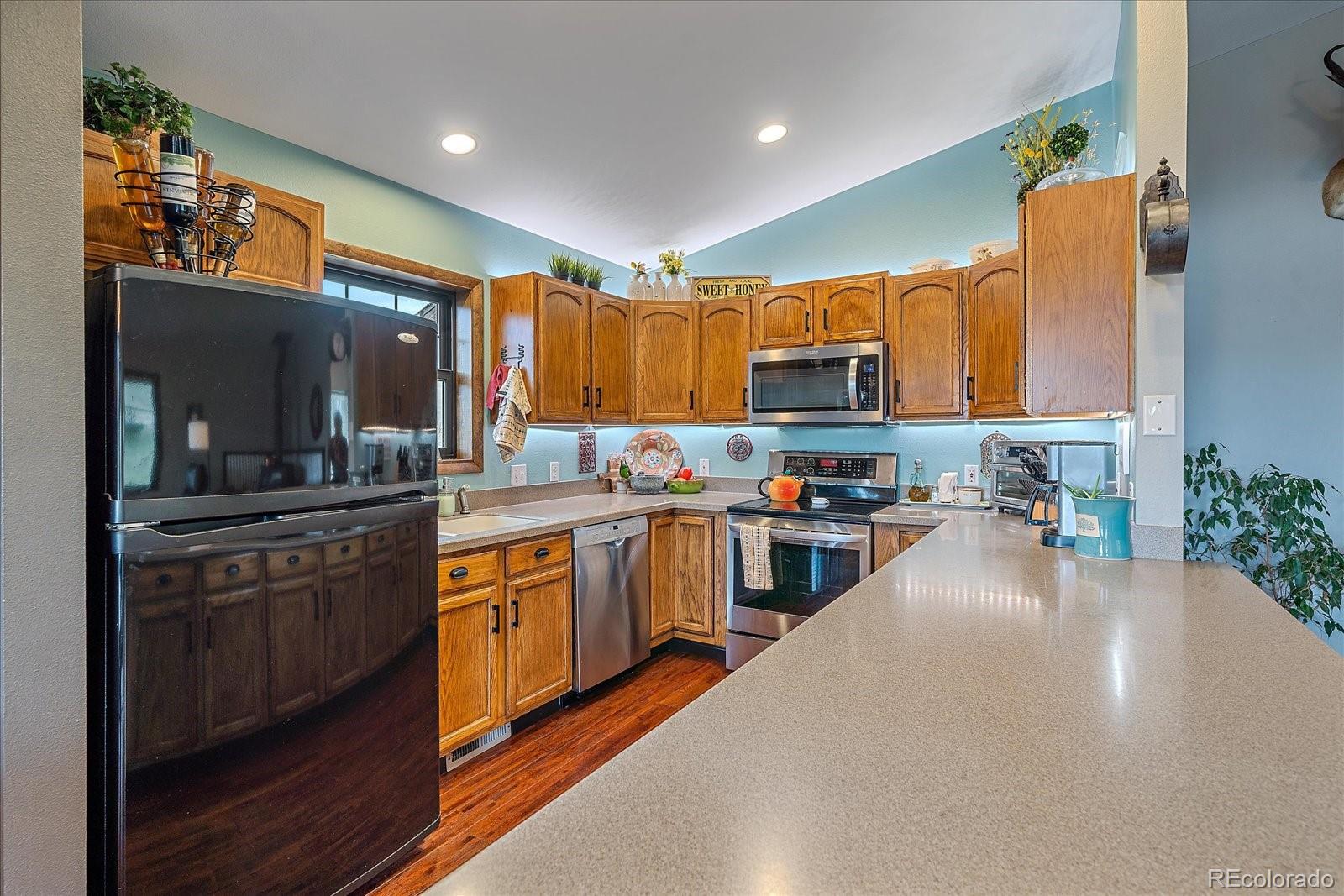 26035 Amy Circle Conifer, CO 80433 - Photo 13 of 38 a kitchen with stainless steel appliances a refrigerator sink stove microwave and cabinets