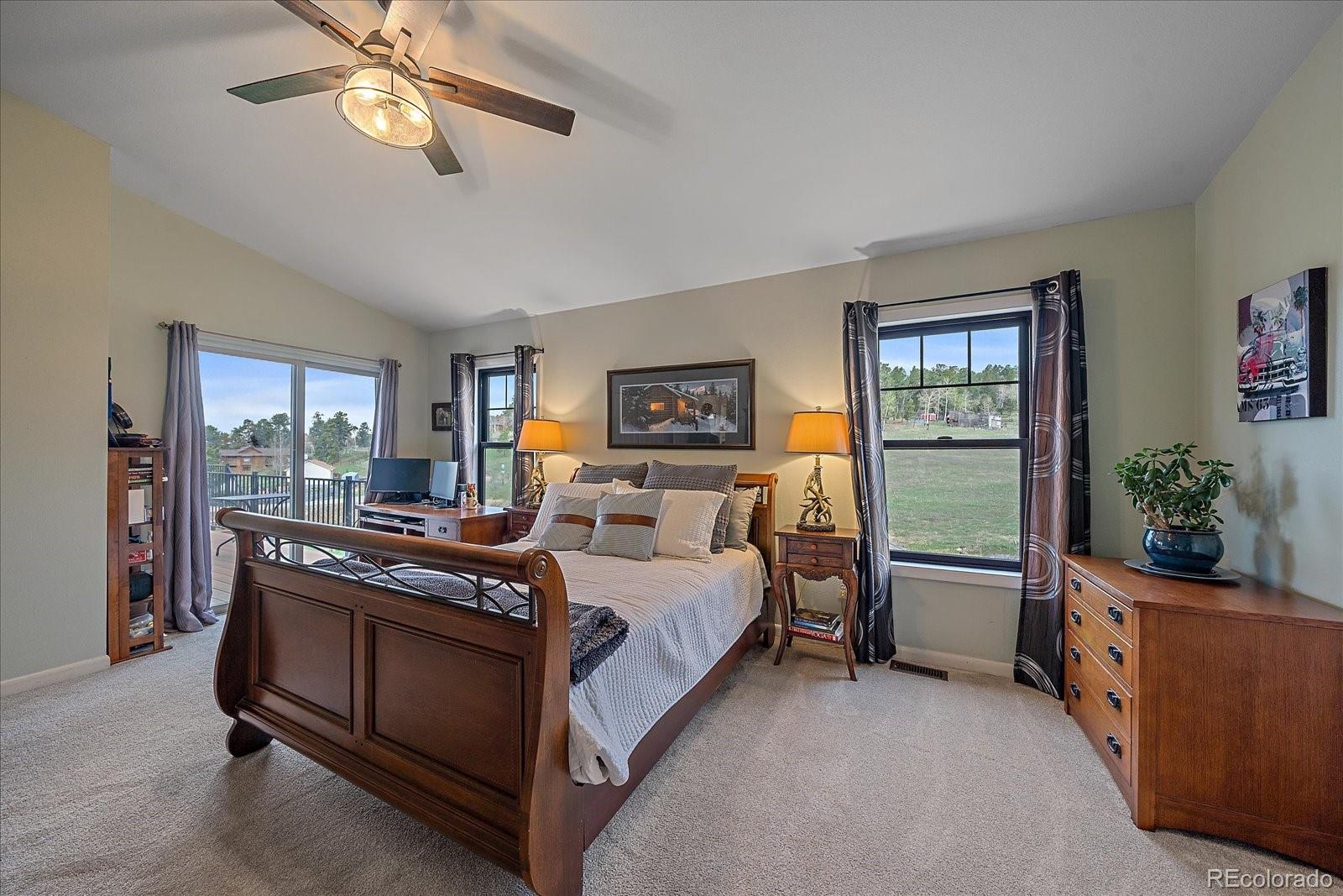 26035 Amy Circle Conifer, CO 80433 - Photo 17 of 38 a bed room with a bed and a chandelier
