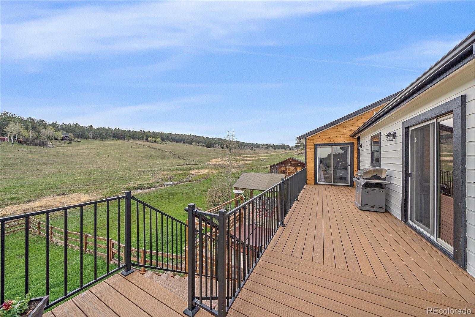 26035 Amy Circle Conifer, CO 80433 - Photo 26 of 38 a view of a balcony with wooden floor and city view