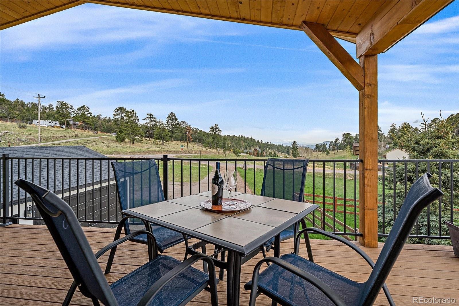 26035 Amy Circle Conifer, CO 80433 - Photo 6 of 38 a view of a balcony with mountain view and wooden floor