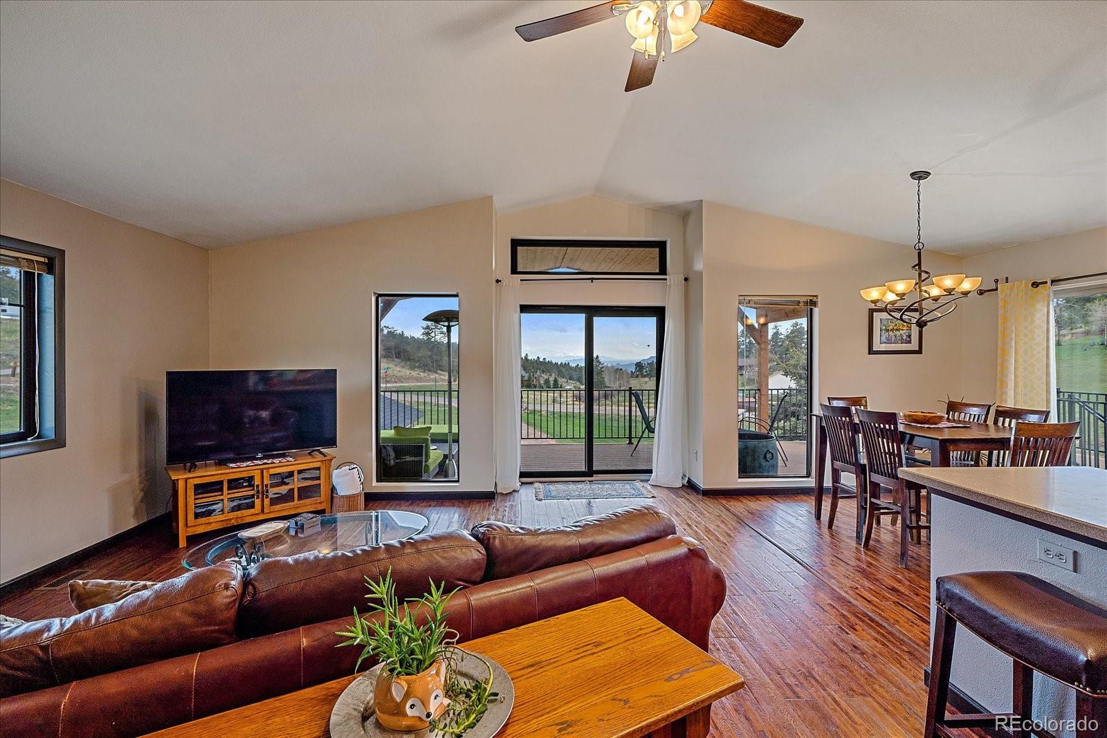 26035 Amy Circle Conifer, CO 80433 - Photo 10 of 38 a living room with furniture a ceiling fan and a flat screen tv
