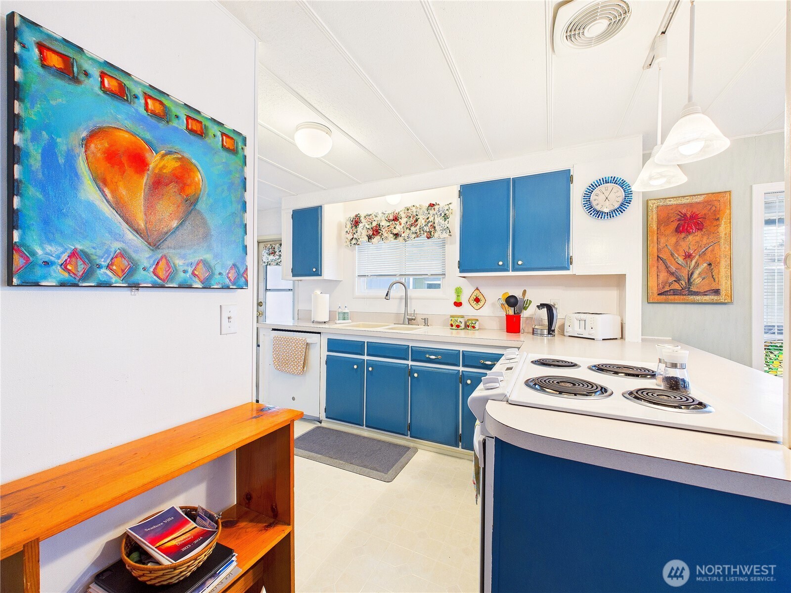 4805 Cushman Road Northeast, Unit 56 Olympia, WA 98506 - Photo 13 of 30 a kitchen with stainless steel appliances a stove a chimney and a dining table with wooden floor
