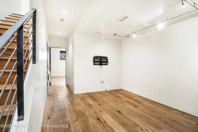 a view of a hallway with wooden floor and staircase