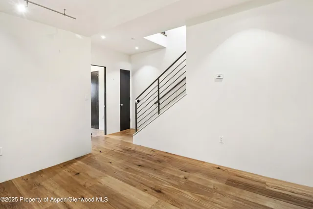 a view of a big room with wooden floor and stairs