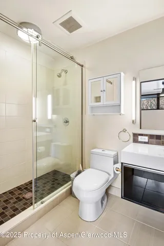 a bathroom with a toilet a sink and shower