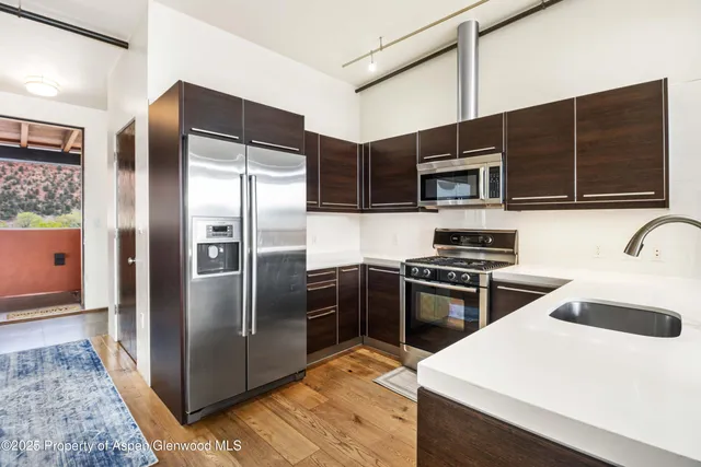 a kitchen with stainless steel appliances kitchen island granite countertop a refrigerator and a stove top oven