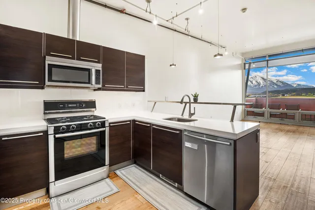 a kitchen with stainless steel appliances kitchen island a stove sink and microwave