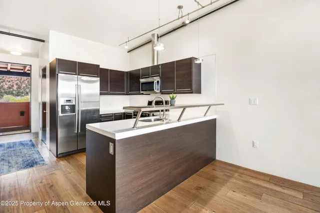 a kitchen with stainless steel appliances a refrigerator and a stove
