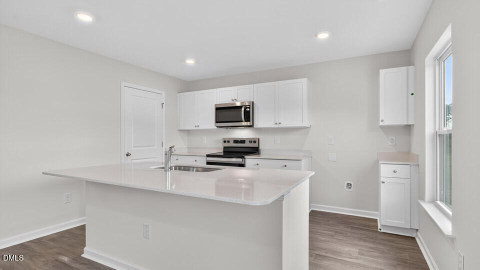 3604 Turney Drive Raleigh, NC 27610 - Photo 11 of 39 a kitchen with a sink a stove a refrigerator a window and white cabinets