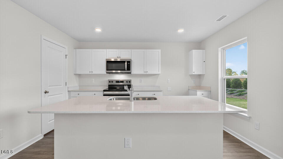 3604 Turney Drive Raleigh, NC 27610 - Photo 10 of 39 a kitchen with stainless steel appliances a sink a stove a microwave a refrigerator a counter top space and cabinets