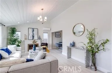 a living room with furniture a potted plant and a chandelier
