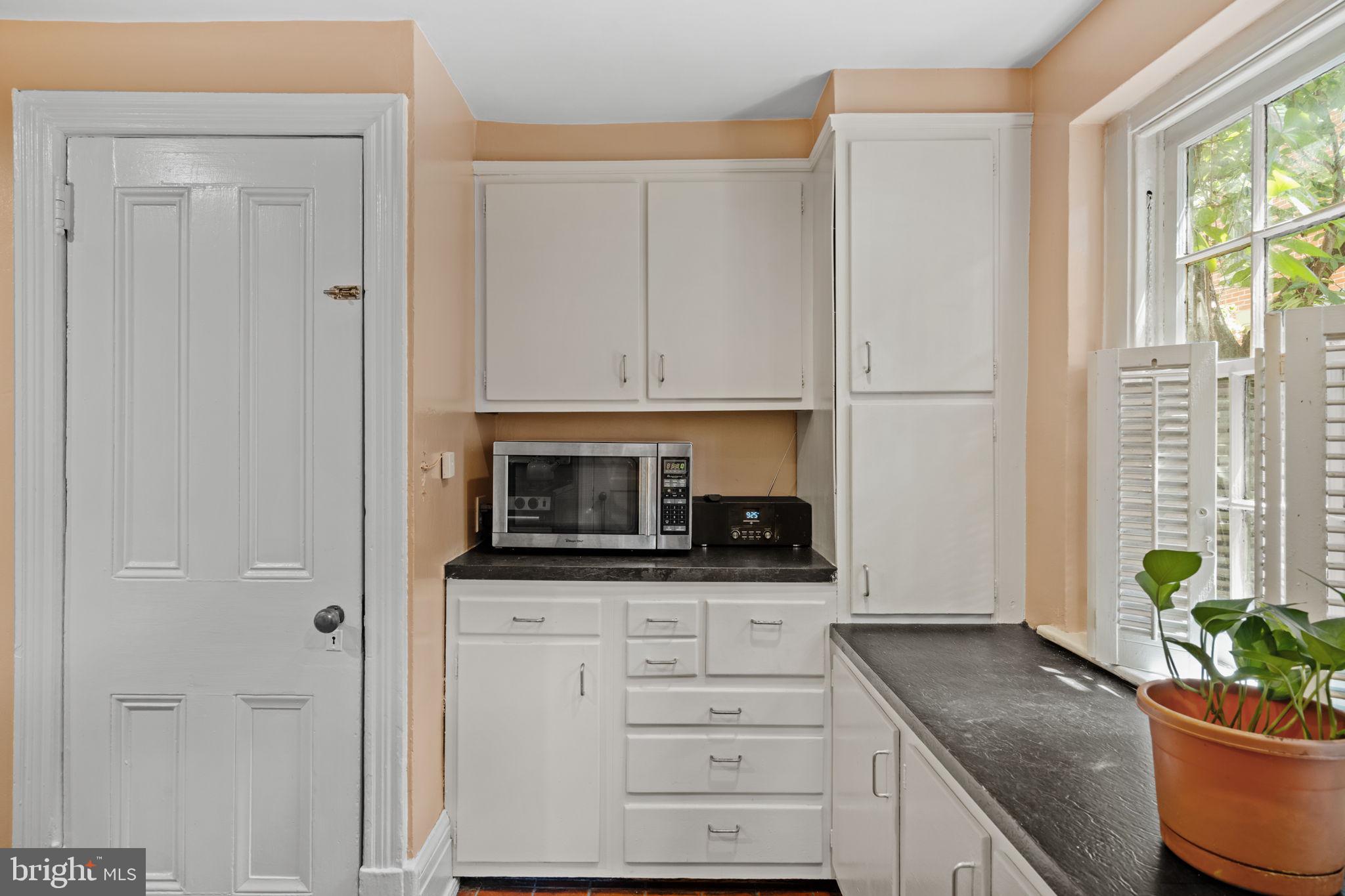 2208 Rittenhouse Square Philadelphia, PA 19103 - Photo 12 of 27 a kitchen with stainless steel appliances white cabinets and a potted plant