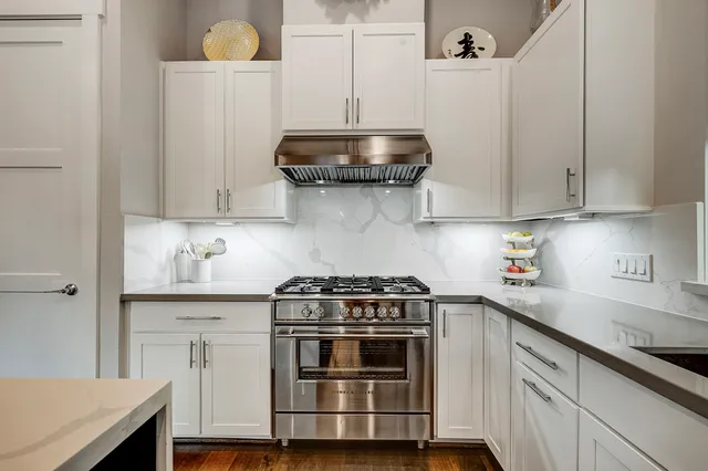 a kitchen with a stove and white cabinets