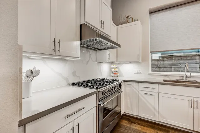 a kitchen with stainless steel appliances a sink a stove and cabinets
