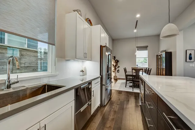 a kitchen with counter top space a sink cabinets and stainless steel appliances