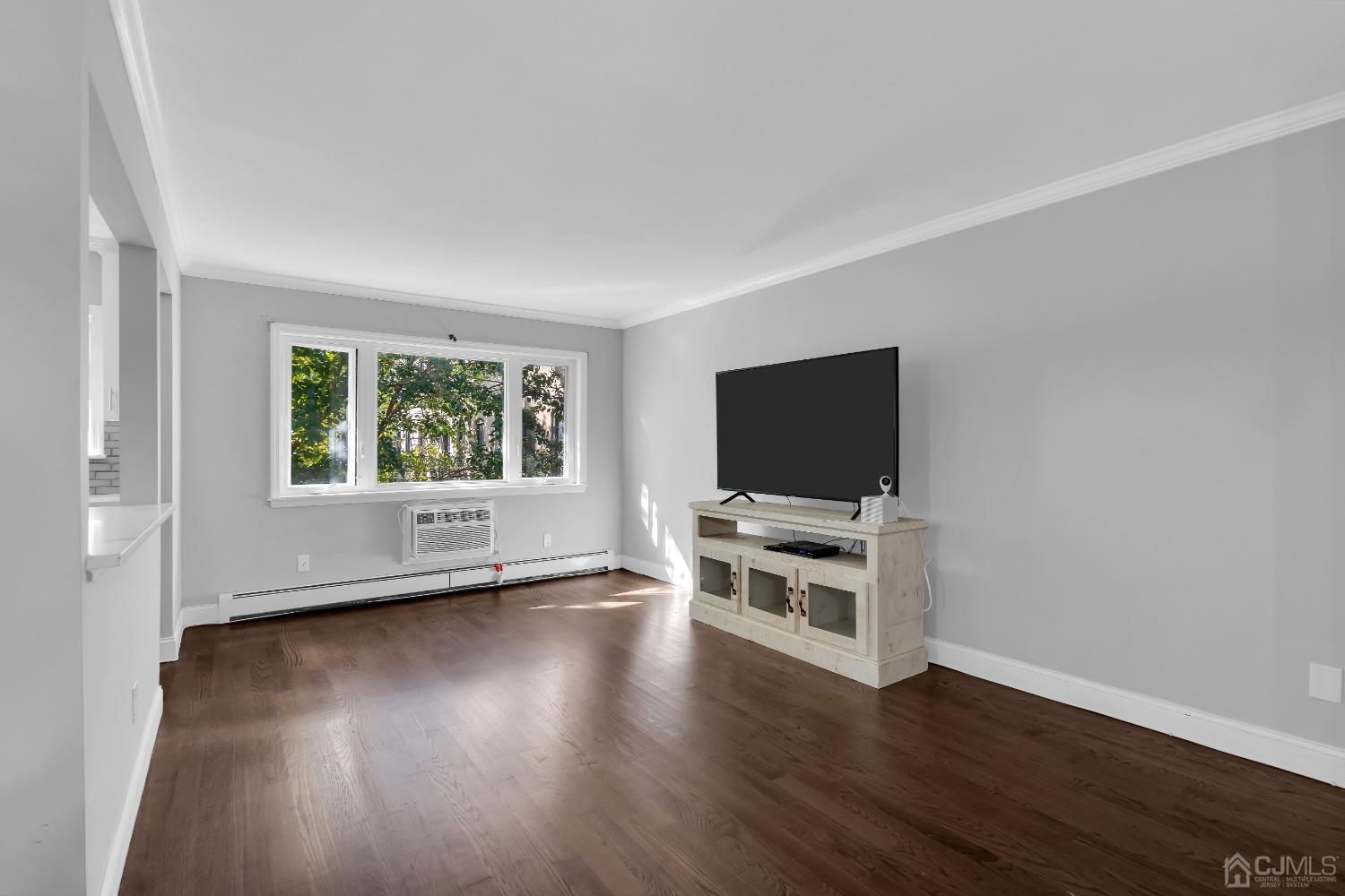 435 Teaneck Road, Unit 21 Ridgefield Park, NJ 07660 - Photo 3 of 20 a view of a livingroom with wooden floor and a flat screen tv