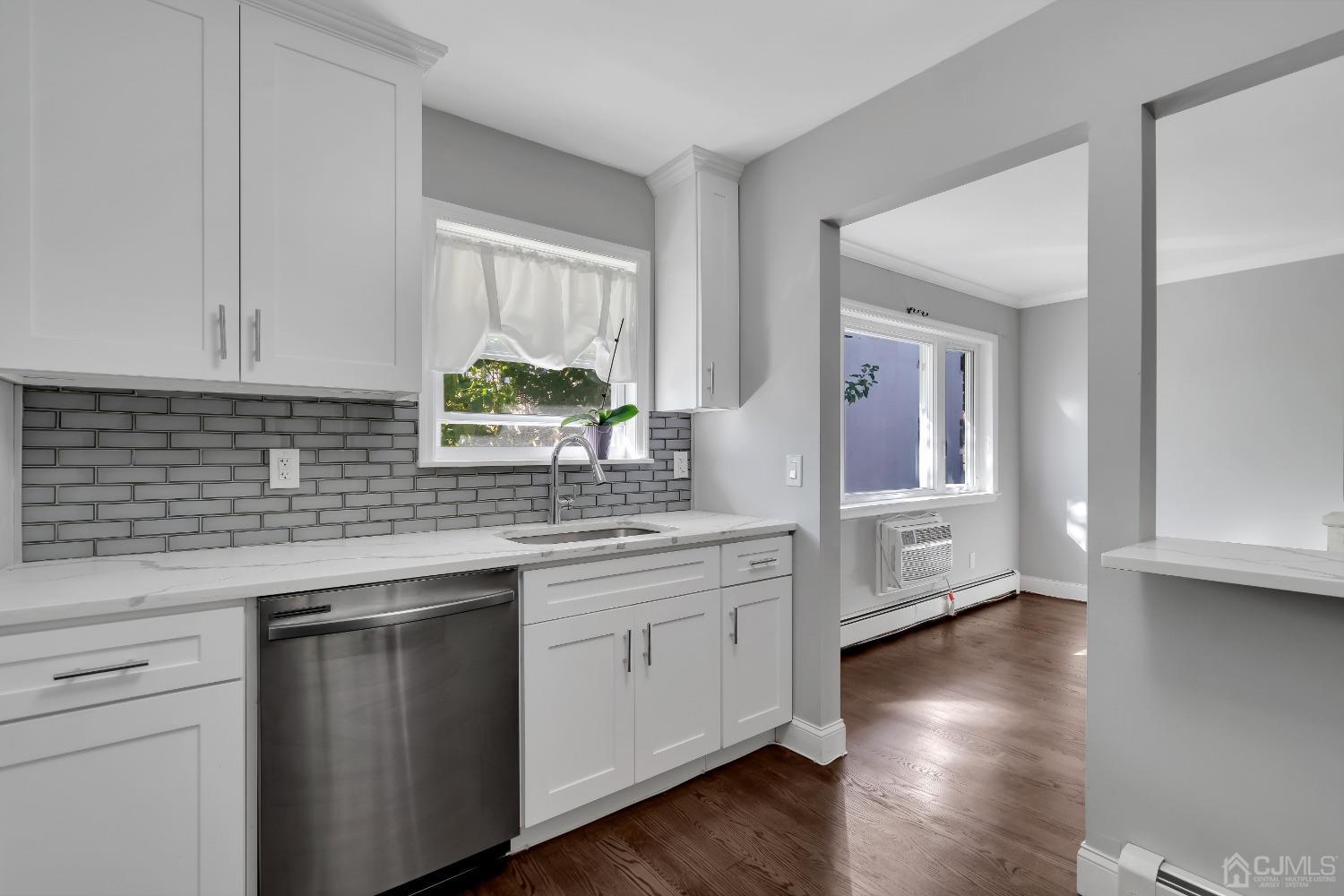 435 Teaneck Road, Unit 21 Ridgefield Park, NJ 07660 - Photo 6 of 20 a kitchen with stainless steel appliances granite countertop white cabinets a sink and dishwasher with wooden floor