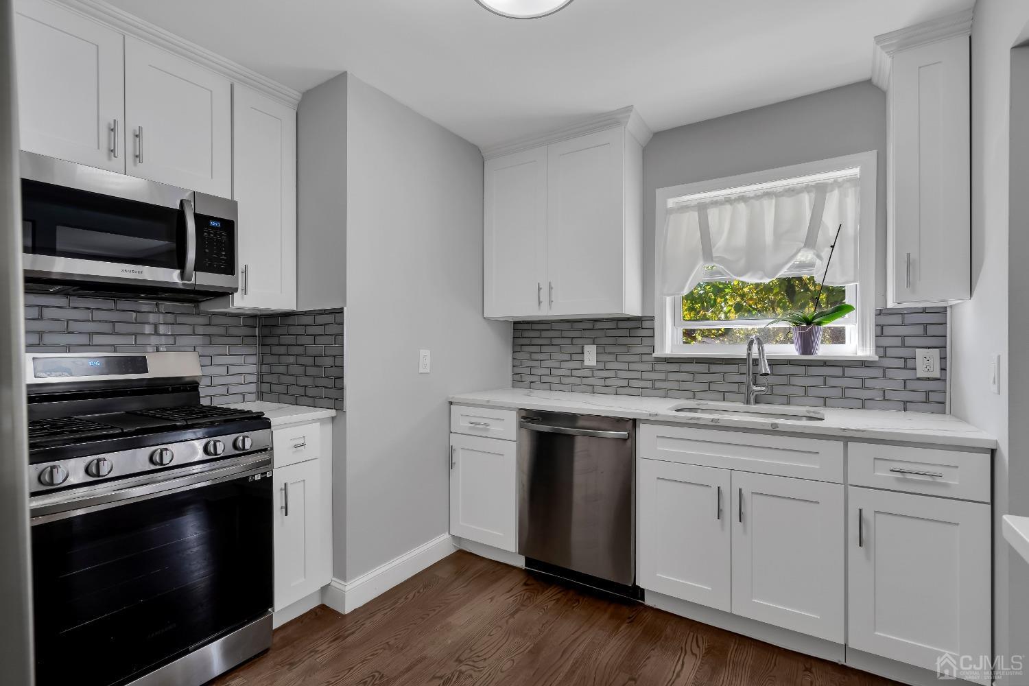 435 Teaneck Road, Unit 21 Ridgefield Park, NJ 07660 - Photo 8 of 20 a kitchen with granite countertop wooden cabinets stainless steel appliances and a wooden floor