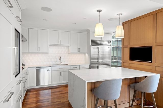 a kitchen with stainless steel appliances granite countertop a kitchen island a stove a table and chairs in it