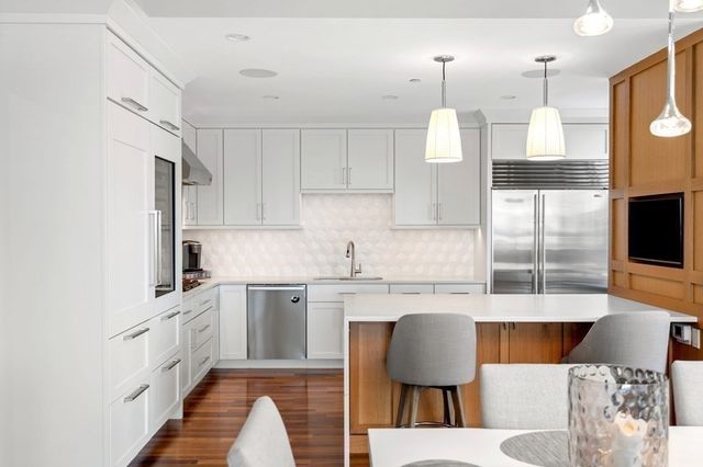 a kitchen with stainless steel appliances granite countertop a sink refrigerator and cabinets