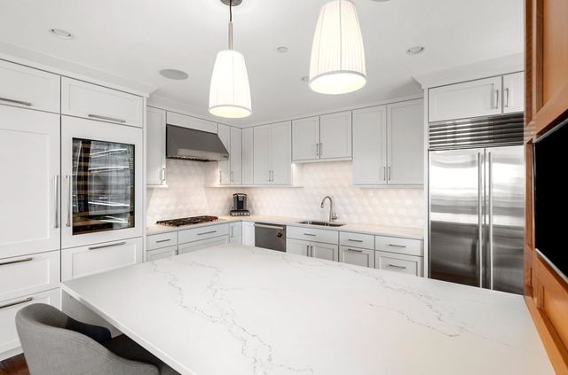 a kitchen with stainless steel appliances kitchen island granite countertop a stove a sink and a refrigerator