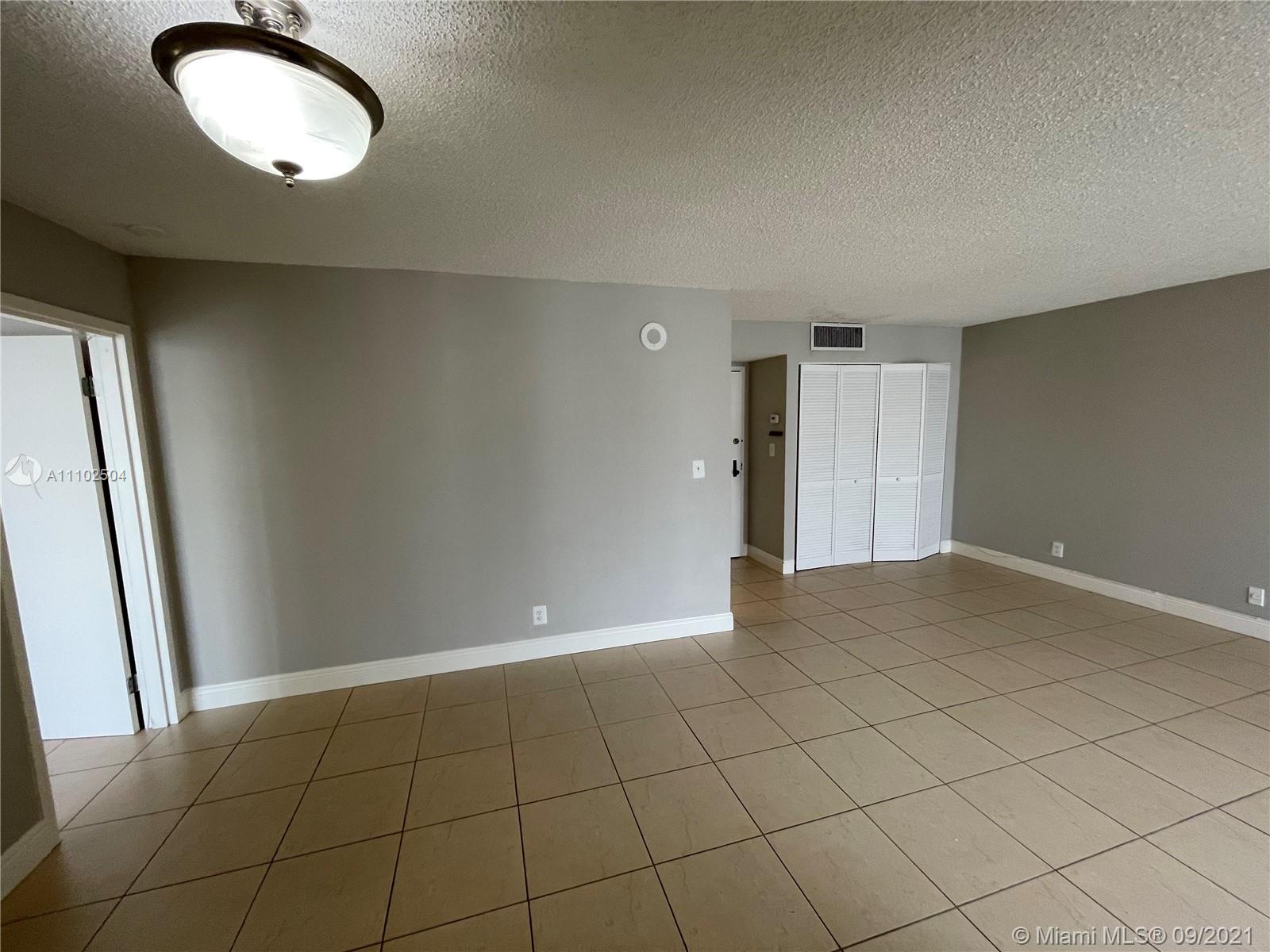 16909 North Bay Road, Unit 807 Sunny Isles Beach, FL 33160 - Photo 12 of 17 an empty room with wooden floor and mirror