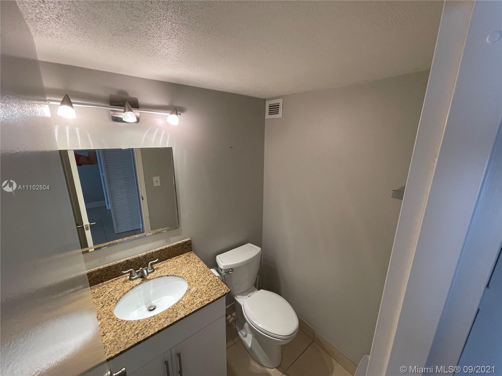 16909 North Bay Road, Unit 807 Sunny Isles Beach, FL 33160 - Photo 17 of 17 a bathroom with a granite countertop sink toilet and mirror